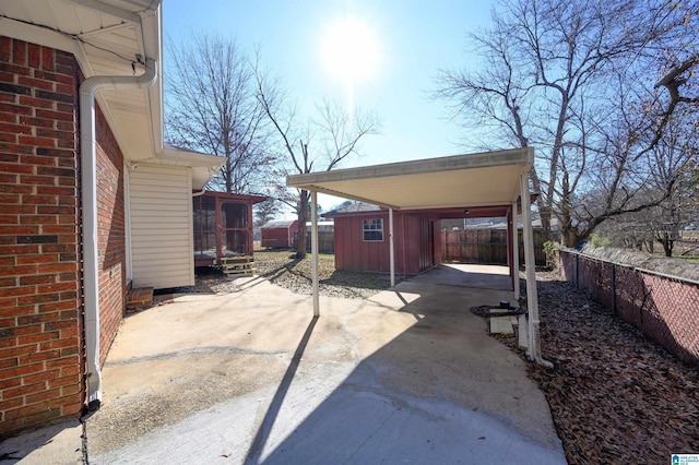 view of patio with a storage unit and a sunroom