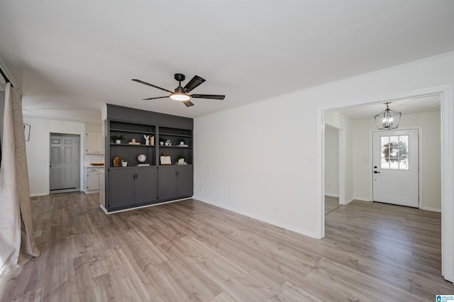 unfurnished living room with wood-type flooring and ceiling fan with notable chandelier