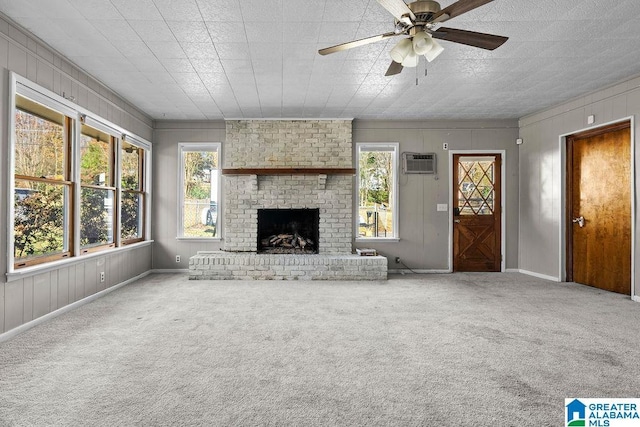 unfurnished living room featuring carpet flooring, a fireplace, and a healthy amount of sunlight