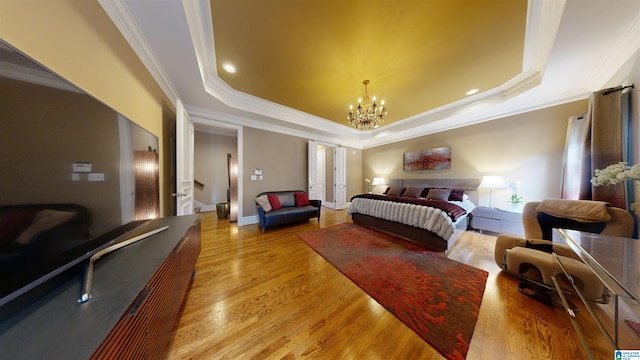 bedroom featuring a tray ceiling, a chandelier, crown molding, and light hardwood / wood-style floors