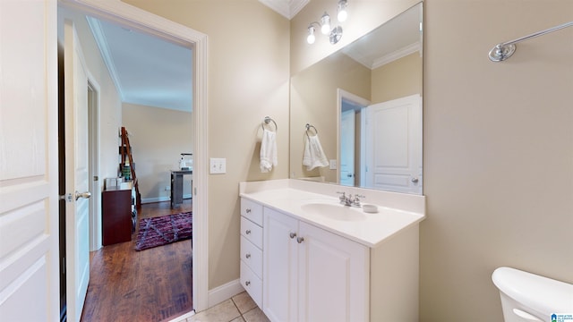 bathroom featuring toilet, vanity, tile patterned floors, and crown molding