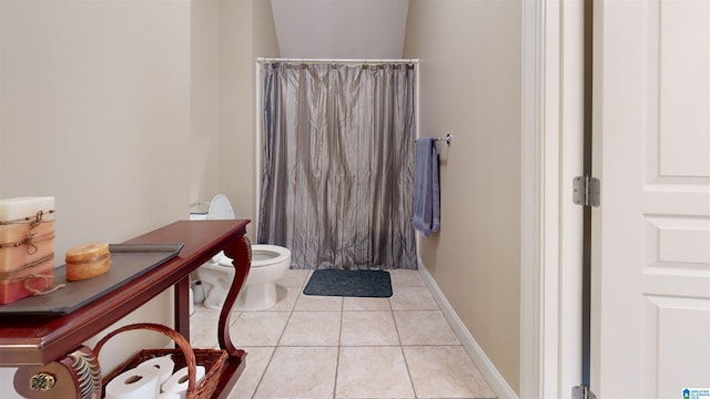 bathroom featuring tile patterned flooring, a shower with shower curtain, and toilet