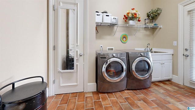 laundry area with washer and clothes dryer, cabinets, and sink