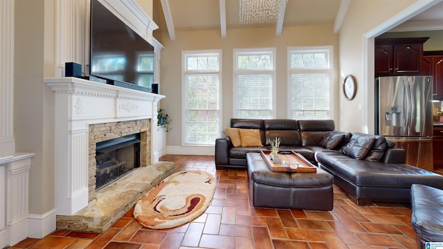 living room with beam ceiling, a fireplace, and a wealth of natural light