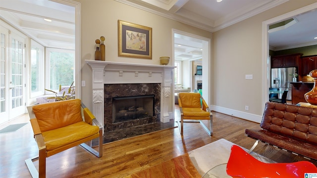 living area featuring a premium fireplace, light hardwood / wood-style floors, and ornamental molding