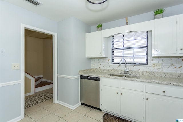 kitchen with tasteful backsplash, dishwasher, sink, light tile patterned floors, and white cabinets