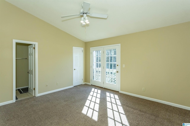 empty room featuring ceiling fan, light colored carpet, and vaulted ceiling