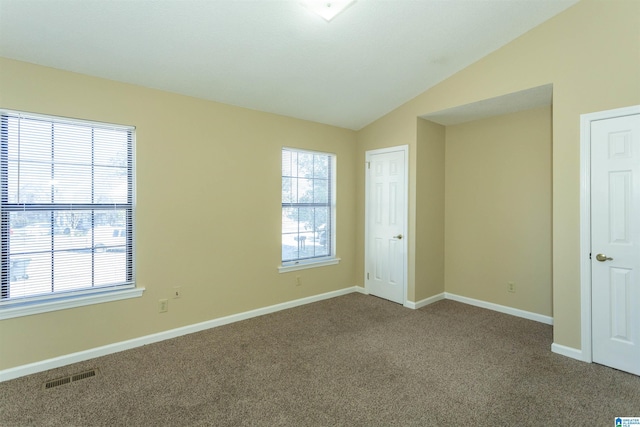 unfurnished bedroom with carpet floors, vaulted ceiling, and multiple windows