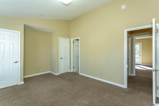 unfurnished bedroom featuring carpet flooring and high vaulted ceiling