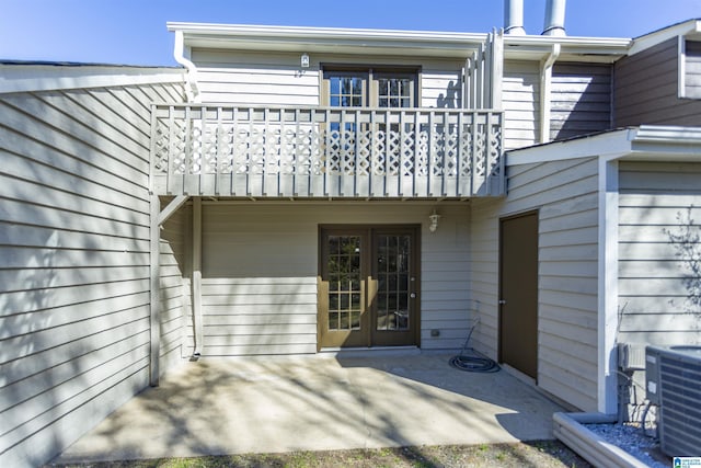 rear view of property featuring cooling unit, a balcony, and a patio