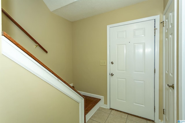 tiled foyer entrance with a textured ceiling