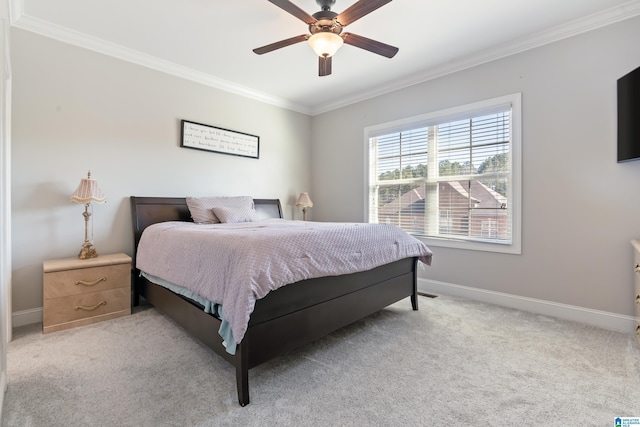 carpeted bedroom featuring ceiling fan and crown molding