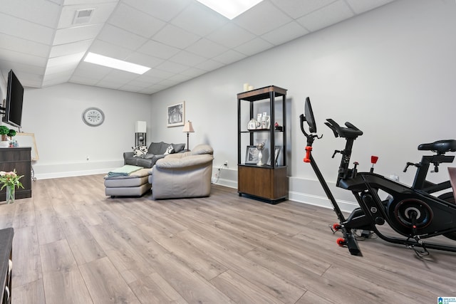 exercise room featuring a paneled ceiling and light hardwood / wood-style floors