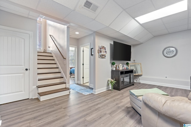 living room with a drop ceiling and light hardwood / wood-style floors