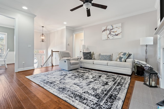 living room featuring crown molding, ceiling fan with notable chandelier, and dark hardwood / wood-style floors