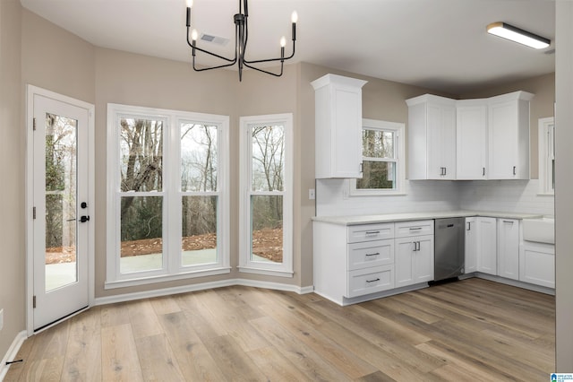 kitchen featuring decorative backsplash, white cabinetry, light hardwood / wood-style flooring, and a chandelier