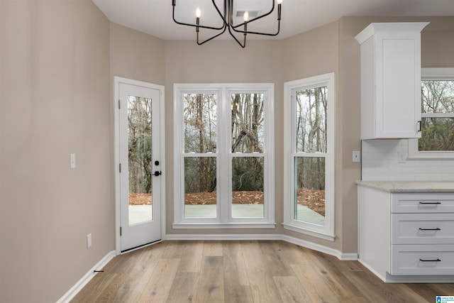 entryway with light wood-type flooring and a chandelier