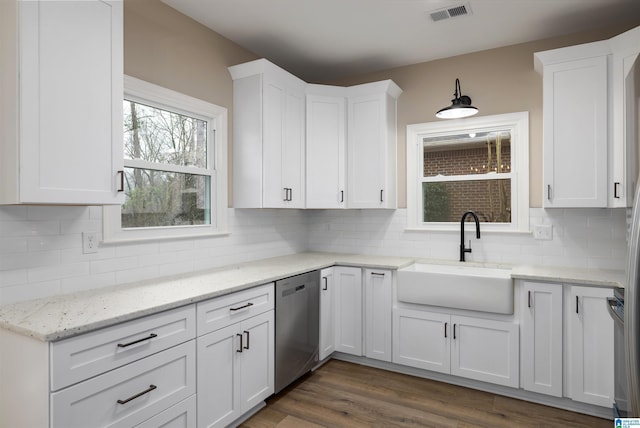 kitchen featuring tasteful backsplash, sink, white cabinets, and stainless steel dishwasher