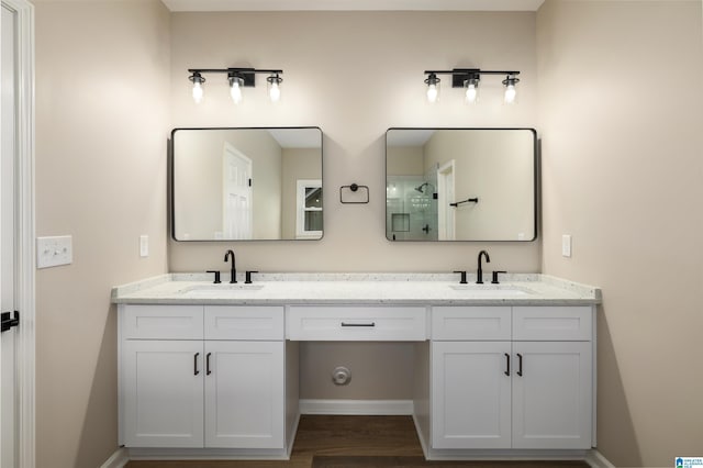 bathroom with hardwood / wood-style flooring, vanity, and a shower