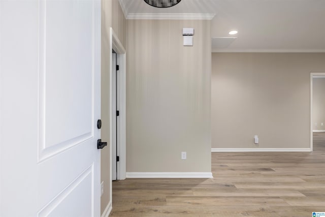 corridor featuring light wood-type flooring and crown molding