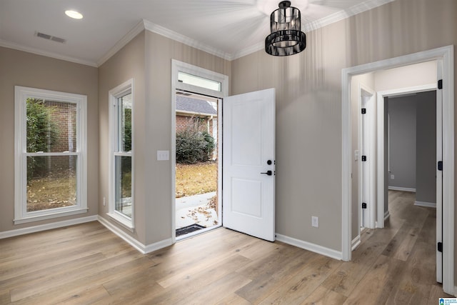 entrance foyer featuring crown molding, light hardwood / wood-style flooring, and a notable chandelier