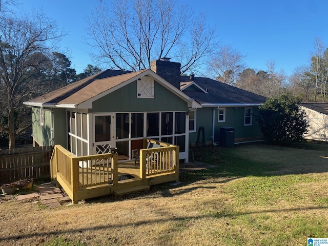 rear view of property with a sunroom, cooling unit, a deck, and a lawn