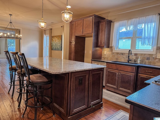 kitchen featuring decorative light fixtures, a center island, a breakfast bar, and tasteful backsplash