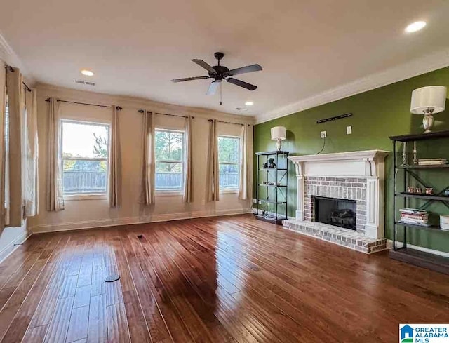 unfurnished living room featuring ceiling fan, a fireplace, crown molding, and hardwood / wood-style flooring