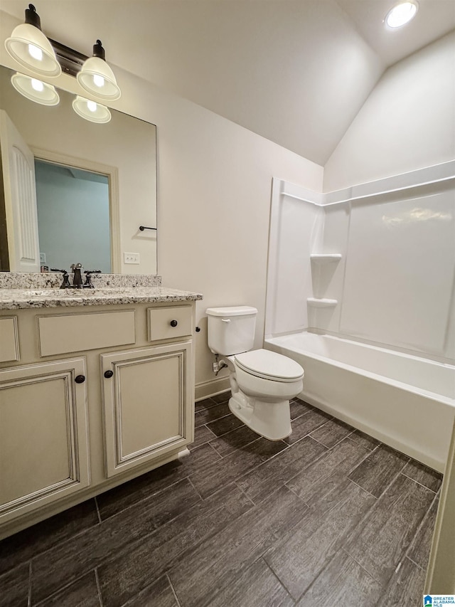 full bathroom with shower / bathtub combination, vanity, vaulted ceiling, and toilet