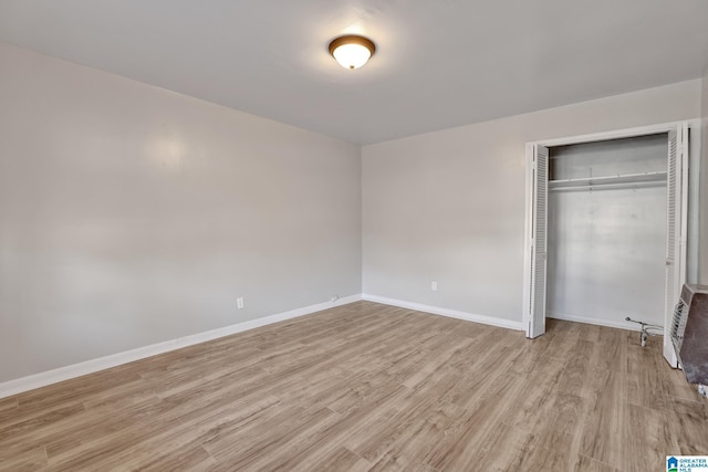 unfurnished bedroom with a closet and light hardwood / wood-style flooring