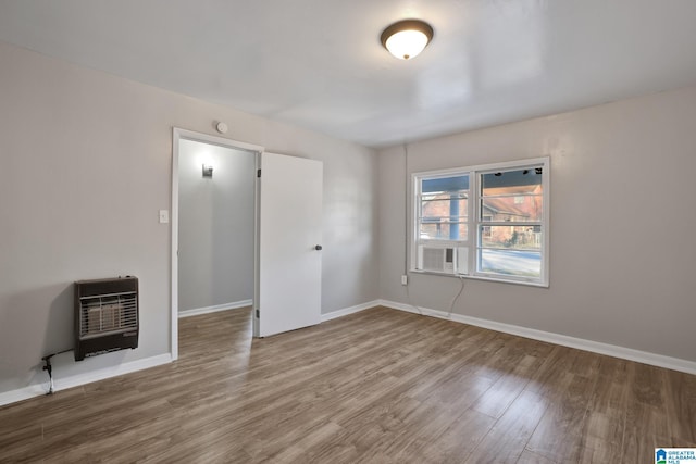 spare room featuring hardwood / wood-style floors and heating unit