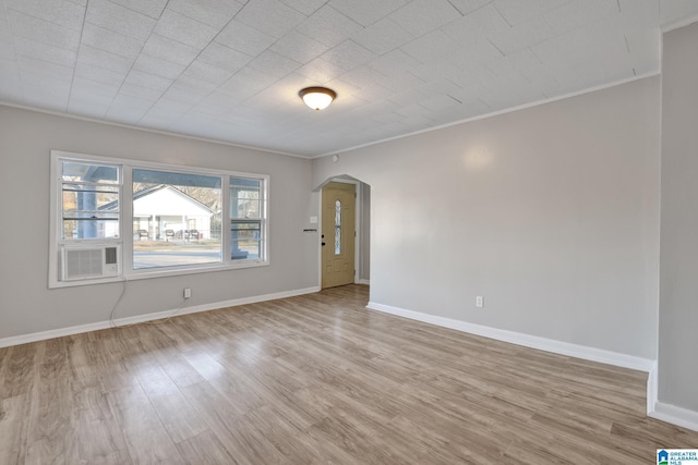 empty room featuring light hardwood / wood-style floors and crown molding