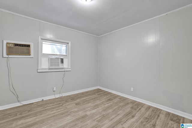 empty room with a wall mounted air conditioner, light hardwood / wood-style floors, and crown molding