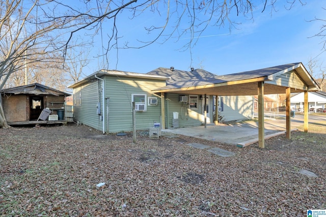 view of front facade featuring a patio area, cooling unit, and a shed