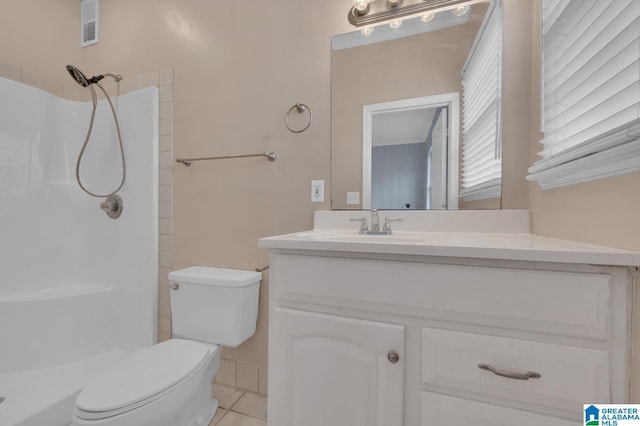 bathroom featuring tile patterned floors, toilet, vanity, and walk in shower