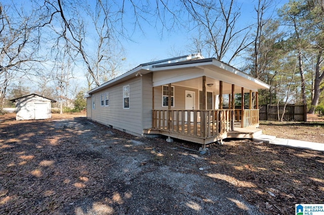 view of front of home with a storage unit and covered porch