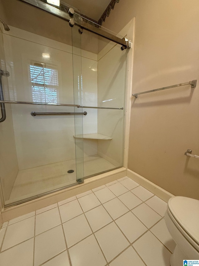 bathroom featuring tile patterned flooring, an enclosed shower, and toilet