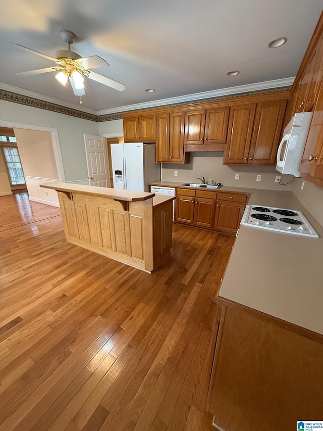 kitchen with a kitchen breakfast bar, light hardwood / wood-style floors, white appliances, a kitchen island, and ornamental molding