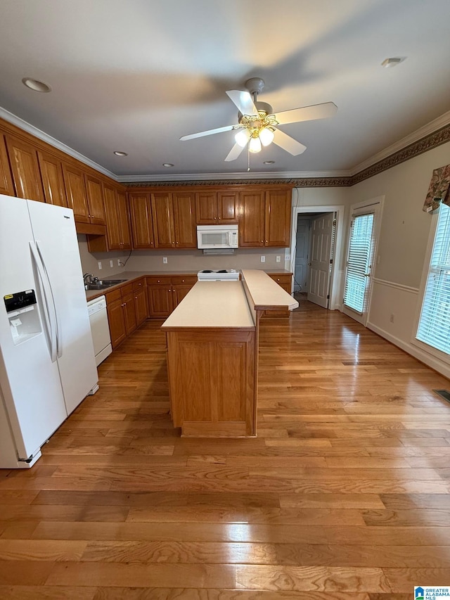 kitchen with light wood-type flooring, white appliances, a center island, and ceiling fan