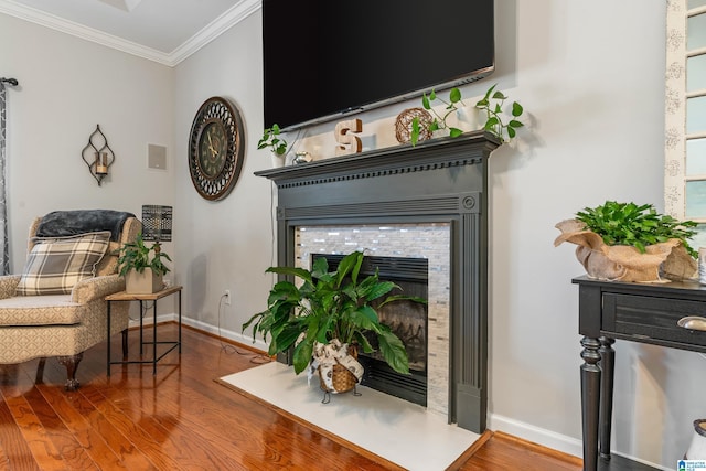 sitting room with hardwood / wood-style floors, ornamental molding, and a tile fireplace