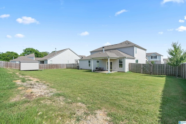 rear view of property featuring a yard, a patio, and a storage shed