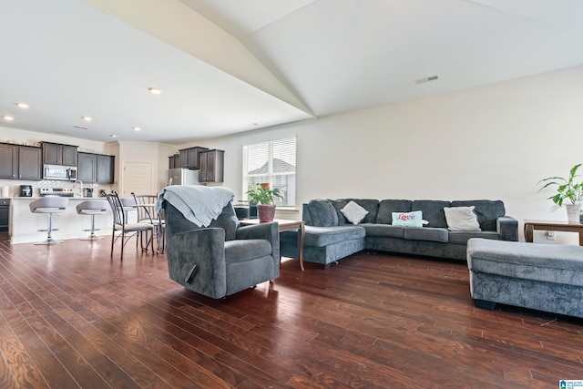 living room featuring dark hardwood / wood-style flooring and lofted ceiling