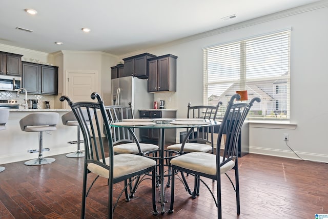 dining space featuring dark hardwood / wood-style floors and ornamental molding