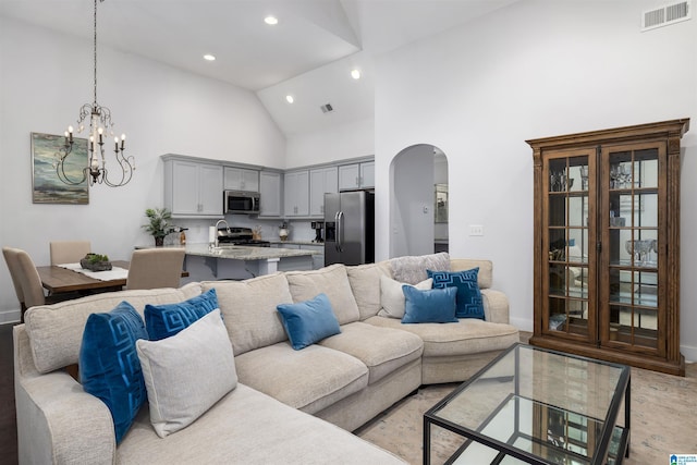 living room with sink, high vaulted ceiling, and a notable chandelier