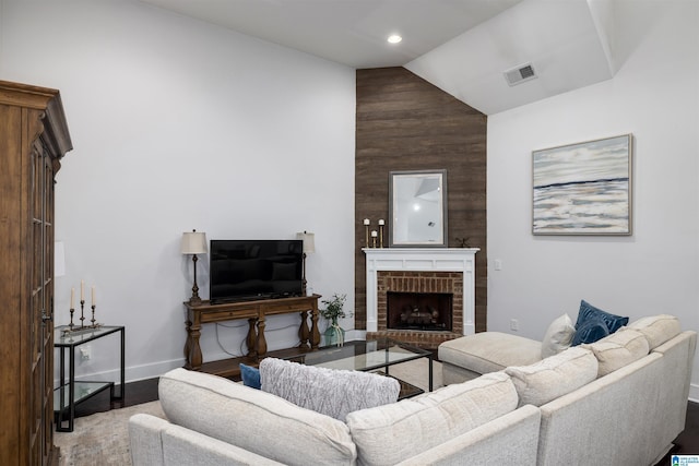 living room with a fireplace, wood-type flooring, and vaulted ceiling