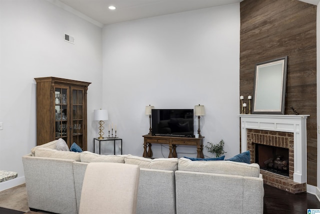 living room featuring dark hardwood / wood-style flooring and a brick fireplace