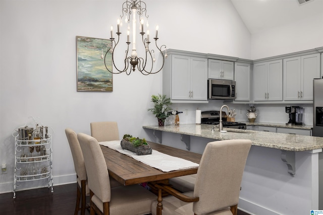 dining area featuring a notable chandelier, dark hardwood / wood-style floors, and high vaulted ceiling