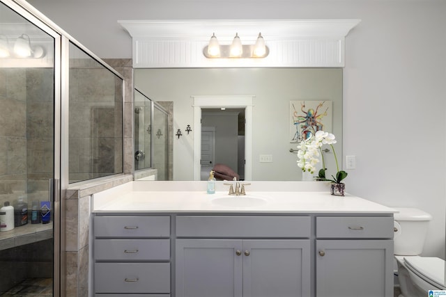 bathroom featuring vanity, an enclosed shower, and toilet