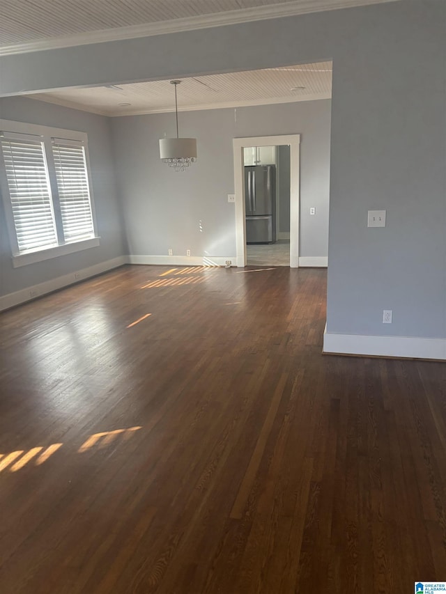 spare room featuring dark hardwood / wood-style flooring and crown molding