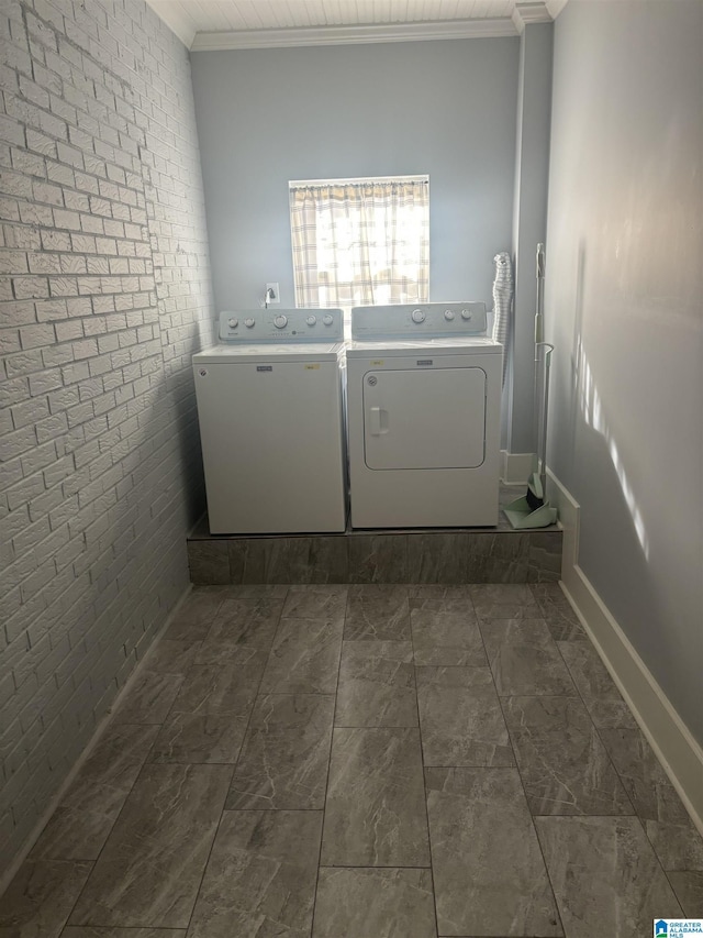 washroom featuring separate washer and dryer, crown molding, and brick wall